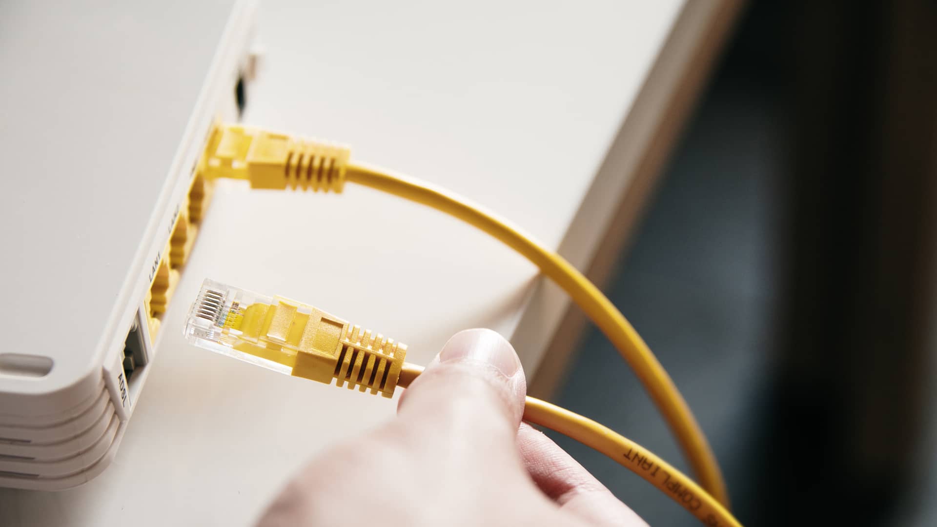 Persona conectando cable de red  para tener internet a moden de compañia att