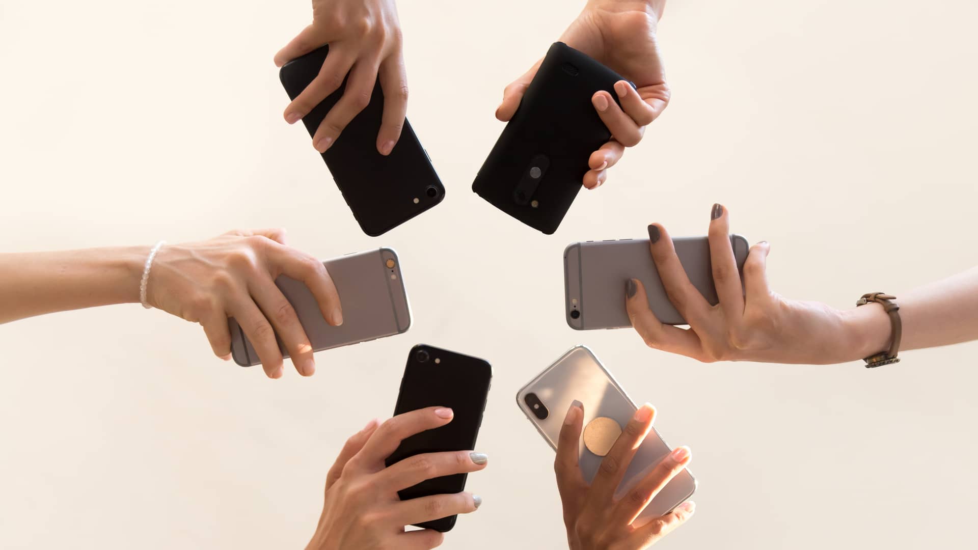 grupo de amigos sujetando sus celulares para comparar cual es el mejor