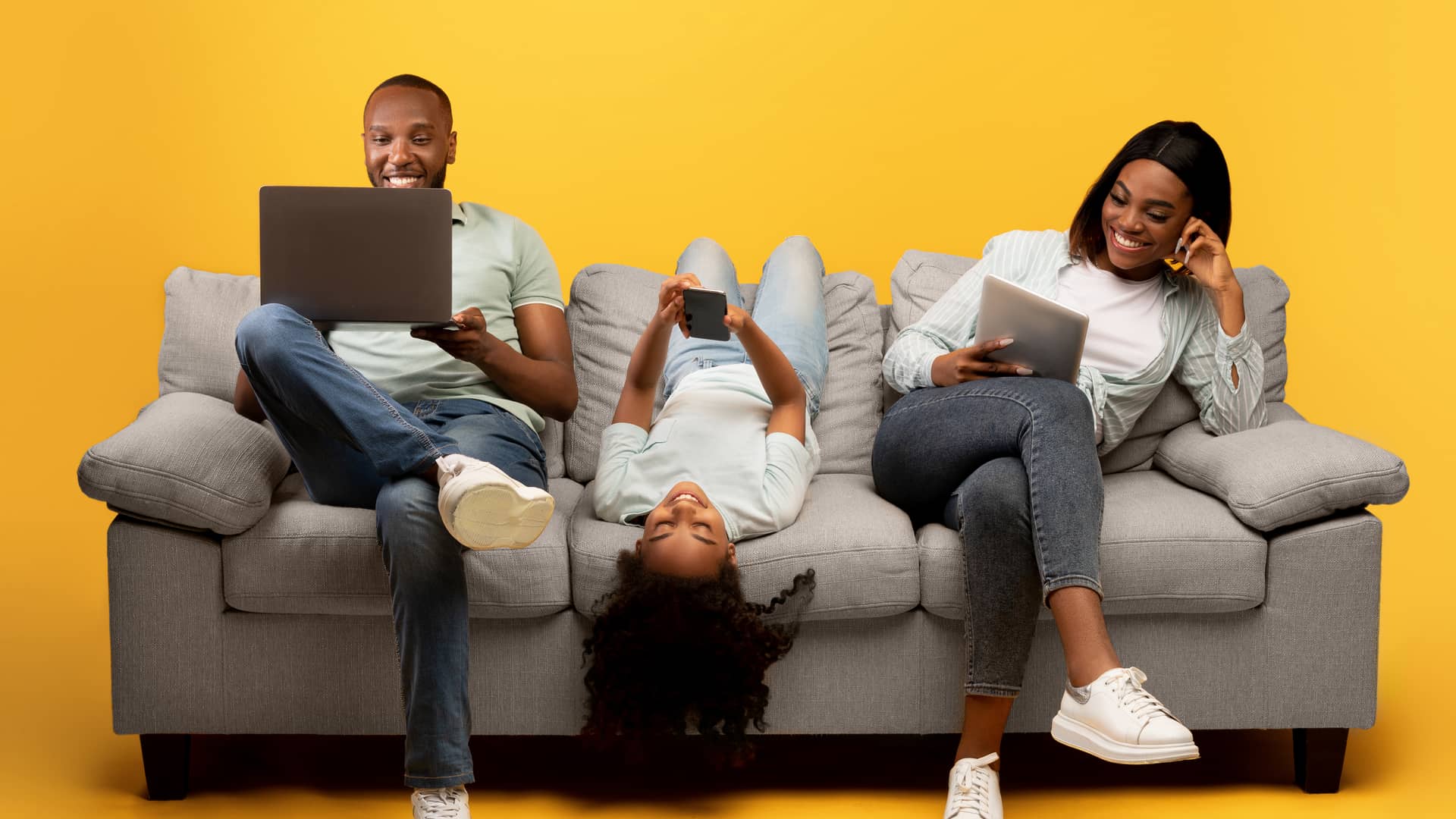 personas en un sofa utilizando celulares porque tienen el mejor servicio de internet segun profeco