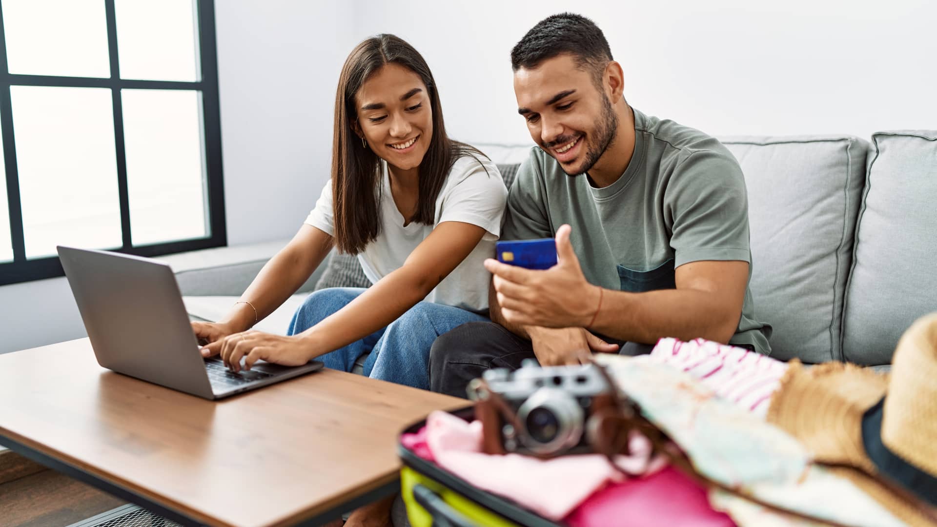 pareja disfrutando de el paquete de internet para su casa con el portatil y el celular