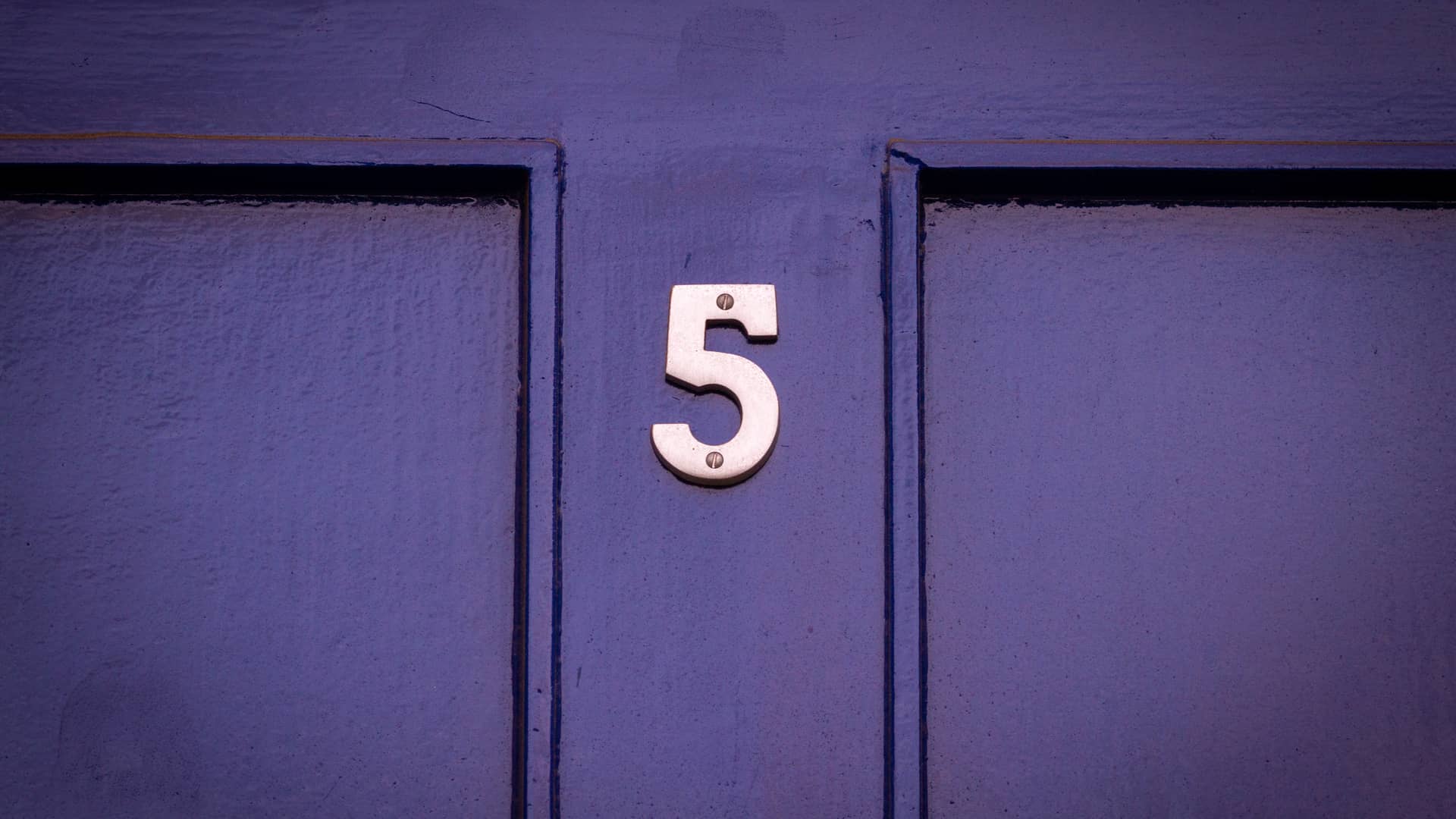una puerta de madera con el numero 5 que indica el canal 5 en vivvo gratis en television