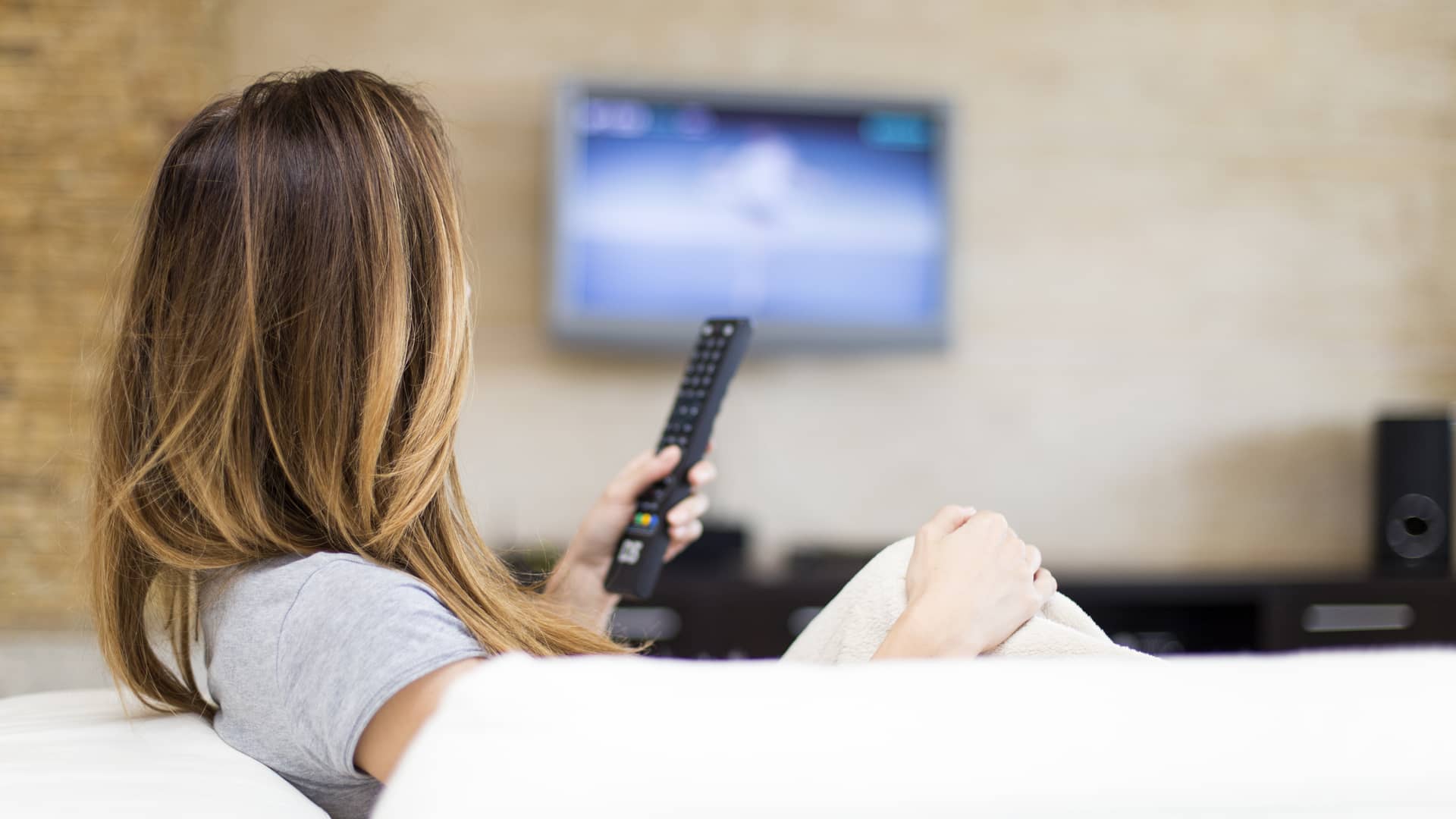 mujer en el sofa de su casa que esta viendo en la tele canales para adultos