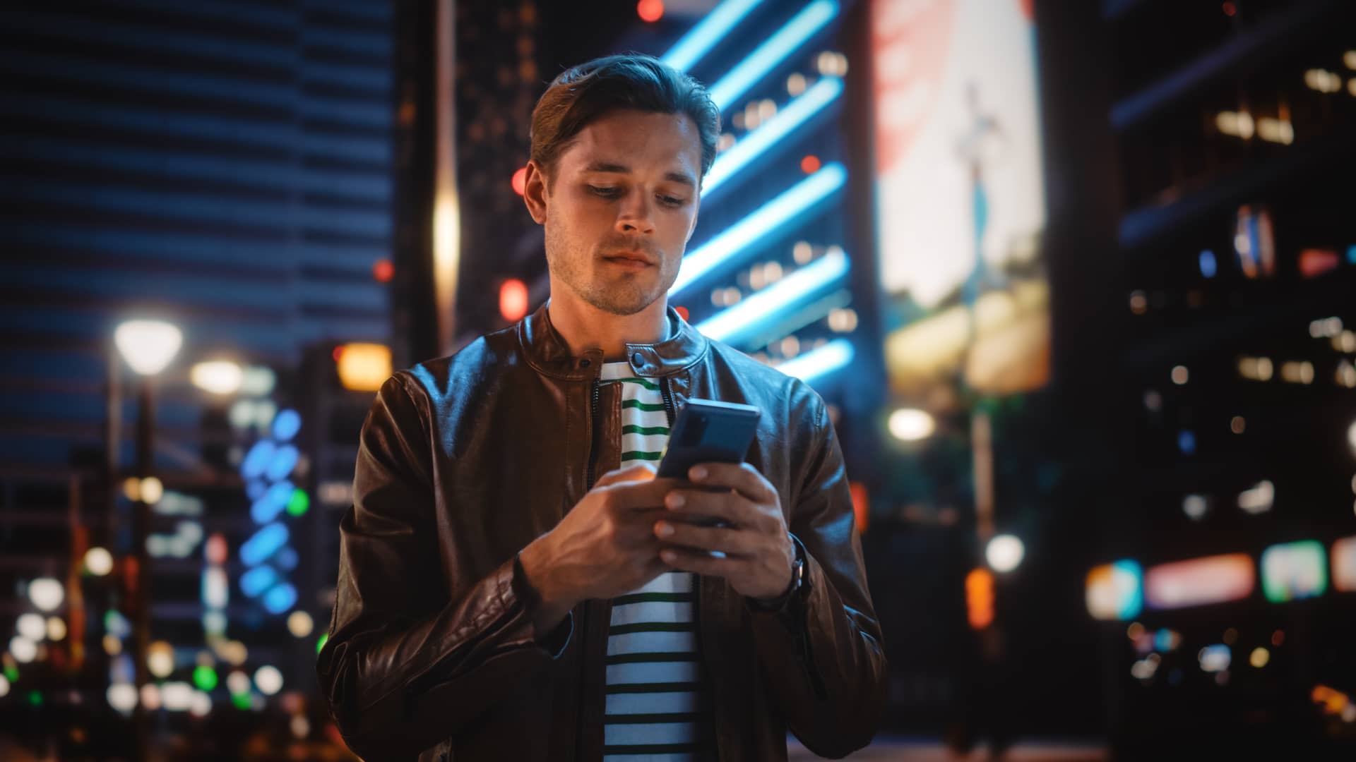 chico en la ciudad mirando en su celular la extension de afizzionados de la empresa izzi