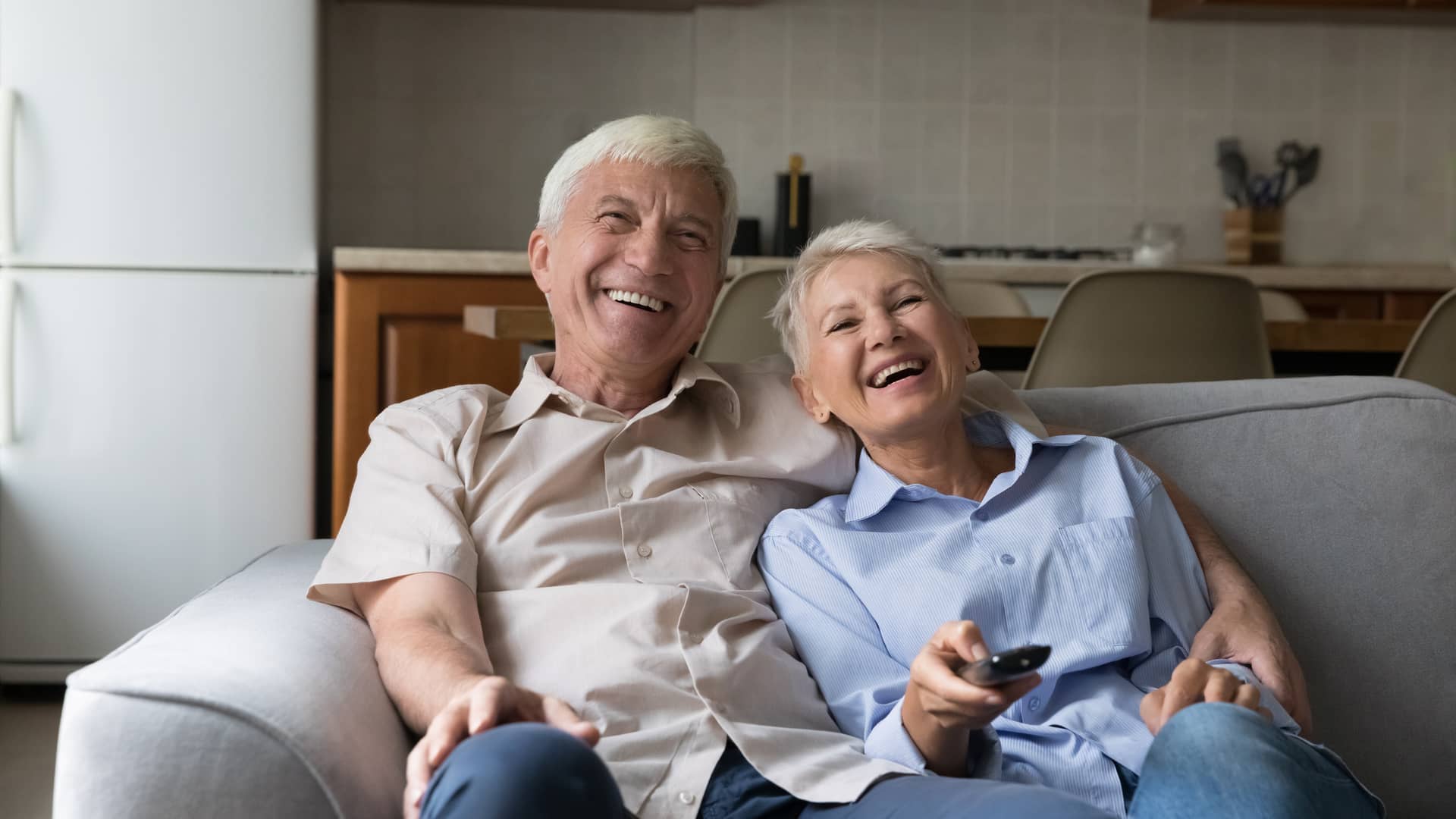 pareja de ancianos revisando la programacion de la television que tiene contratada con izzi