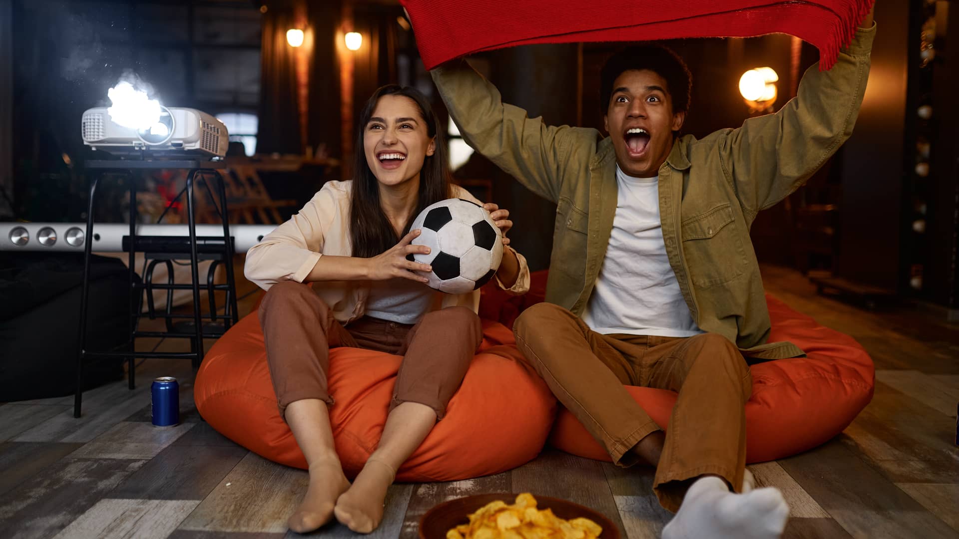 pareja de novios viendo el futbol con un proyector gracias a el canatl tv estrellas con megacable