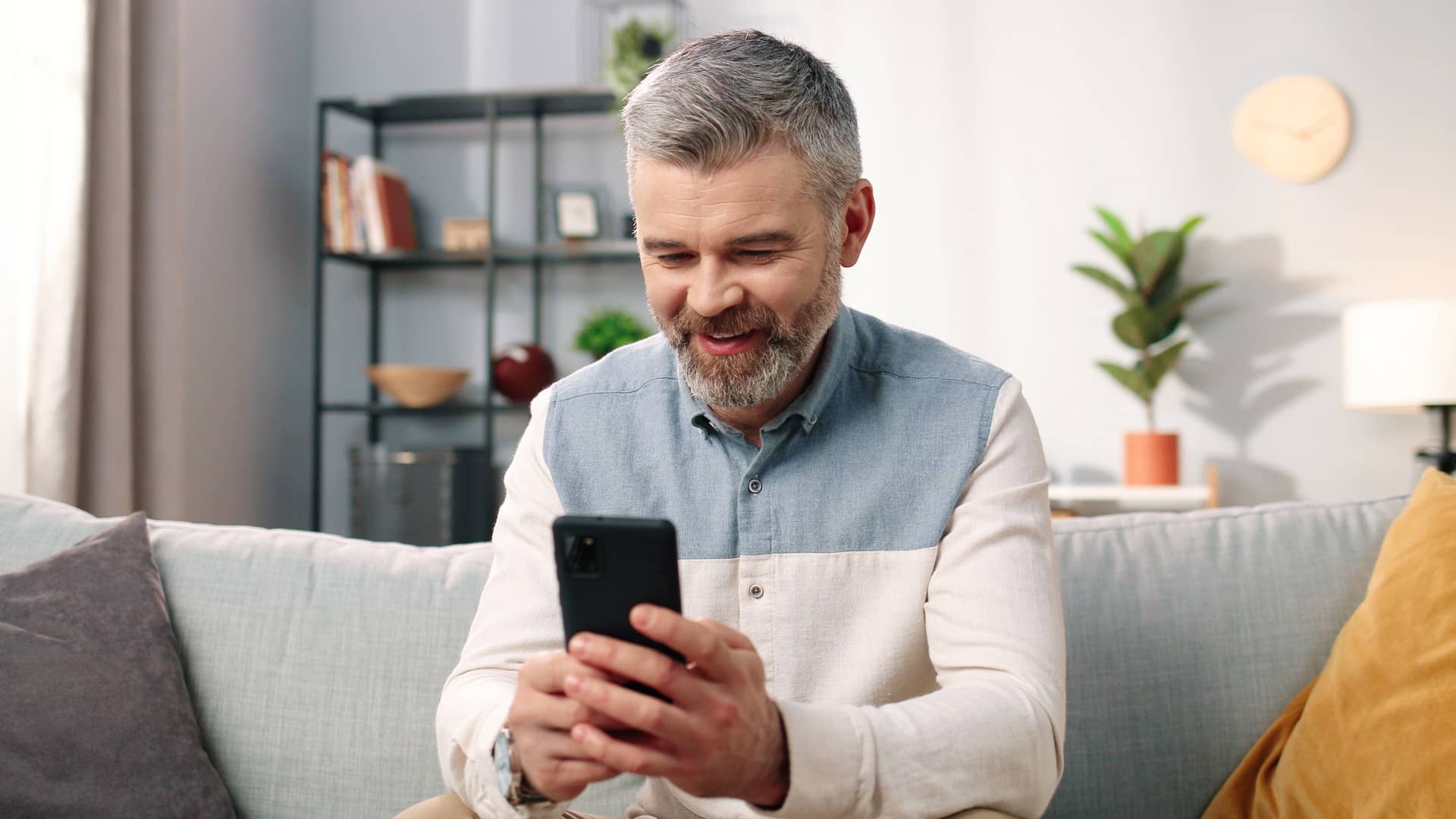 hombre adulto revisando en su celular cual de los paquetes de megacable le sale mas rentable