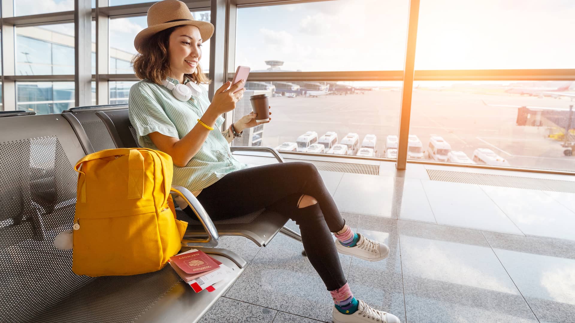 Mujer que esta a punto de embarcarse en un vuelo comprueba en su celular los ajustes del roaming de movistar