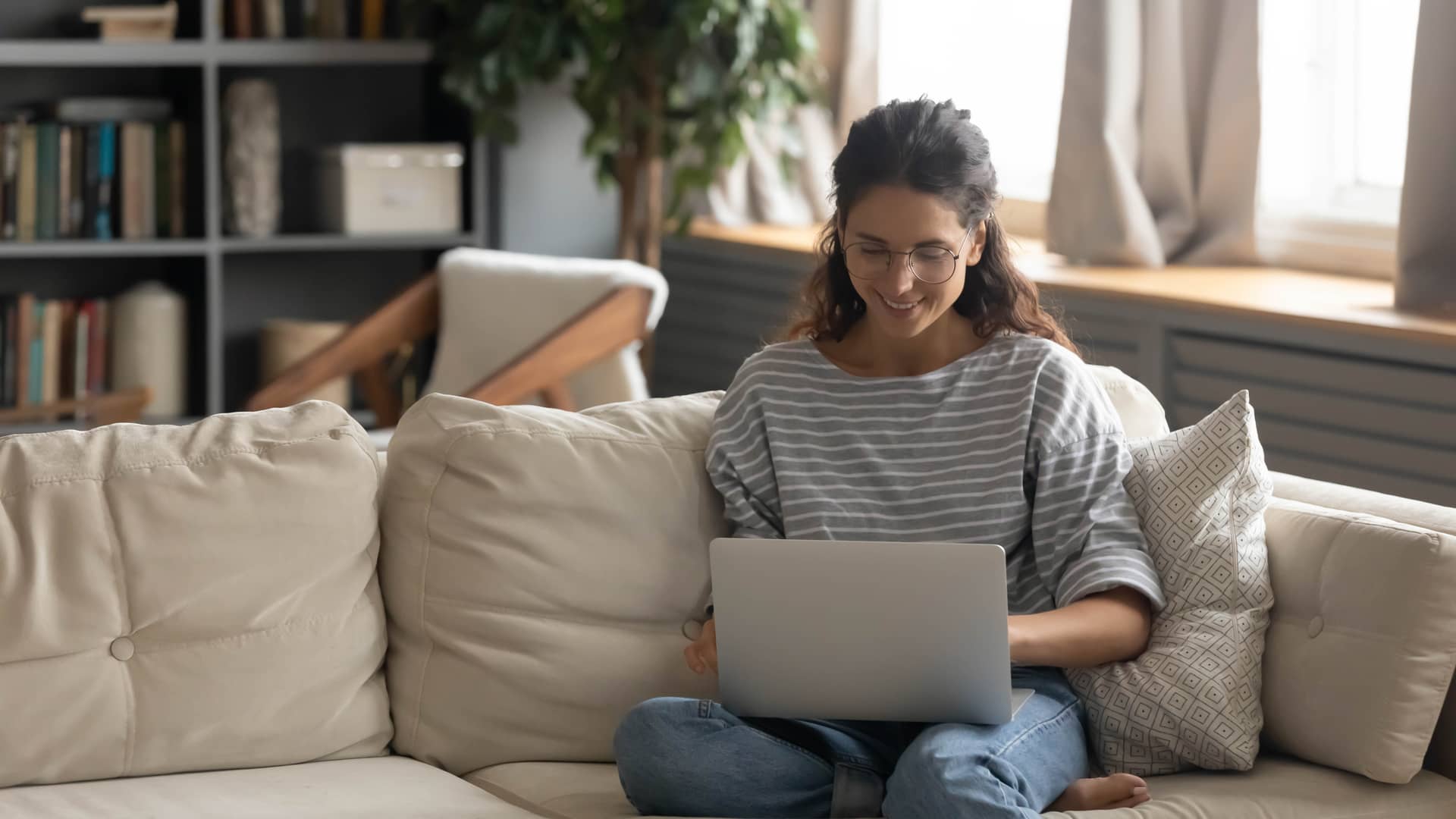 mujer disfrutando del ordenador desde el sofa de su casa gracias a un internet de modem de sky