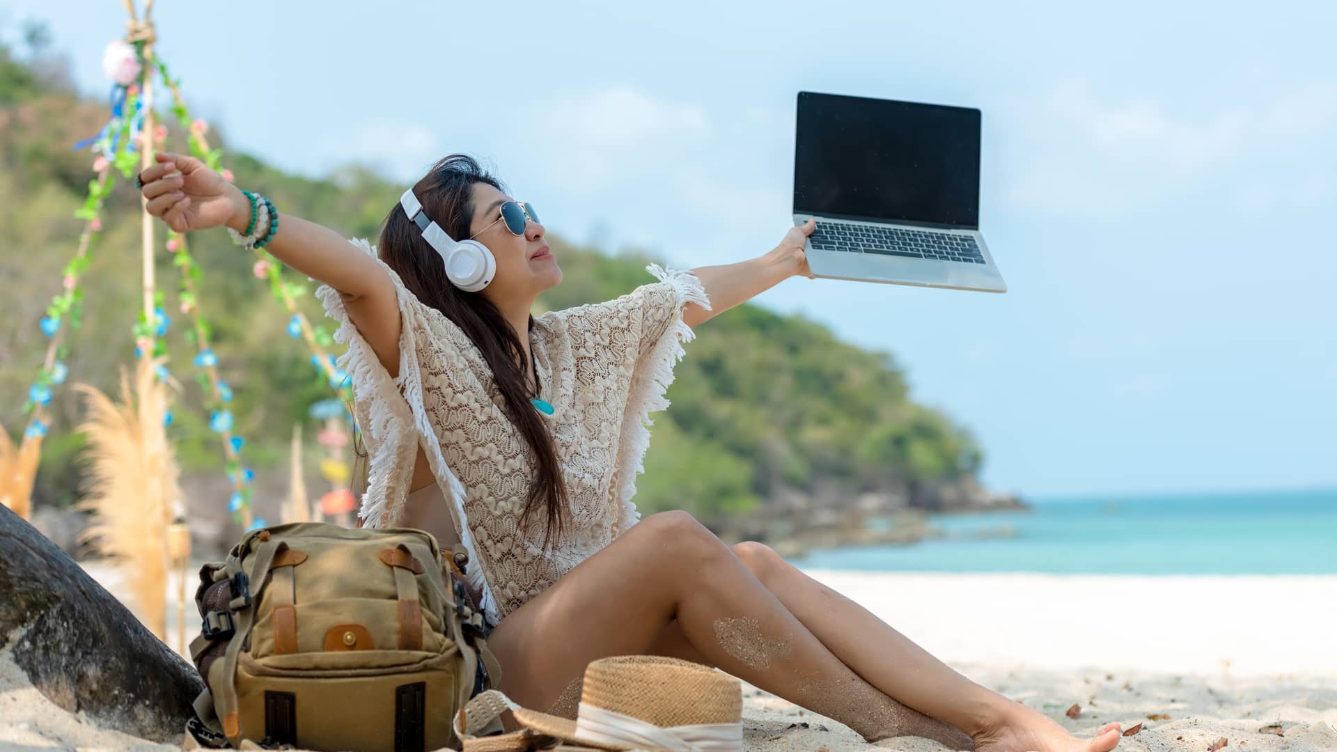 joven en la playa con su ordenador disfrutanto del servicio blue to go de sky