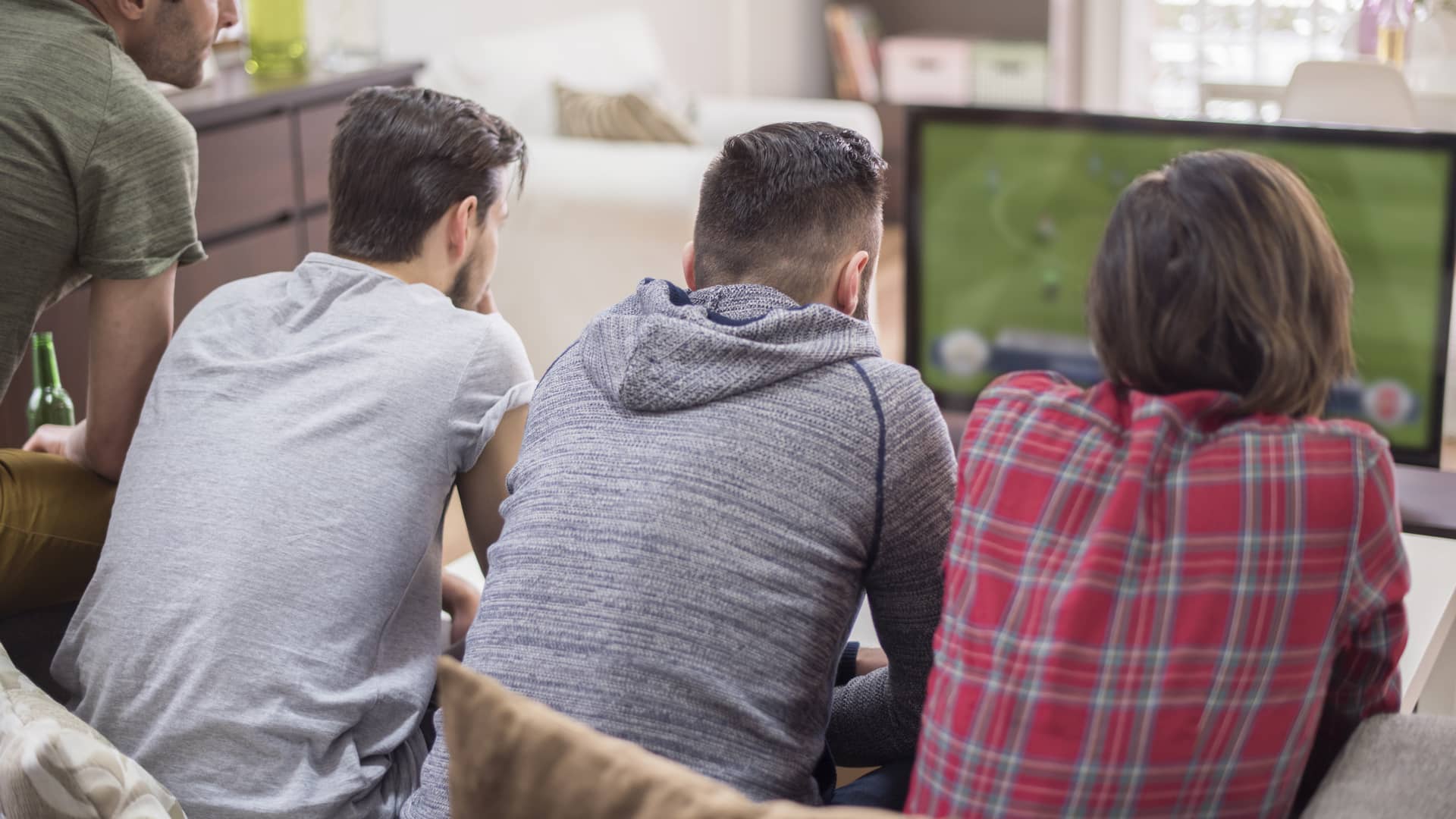 jovenes viendo el futbol en la tv gracuas al pago por evento que ofrece sky