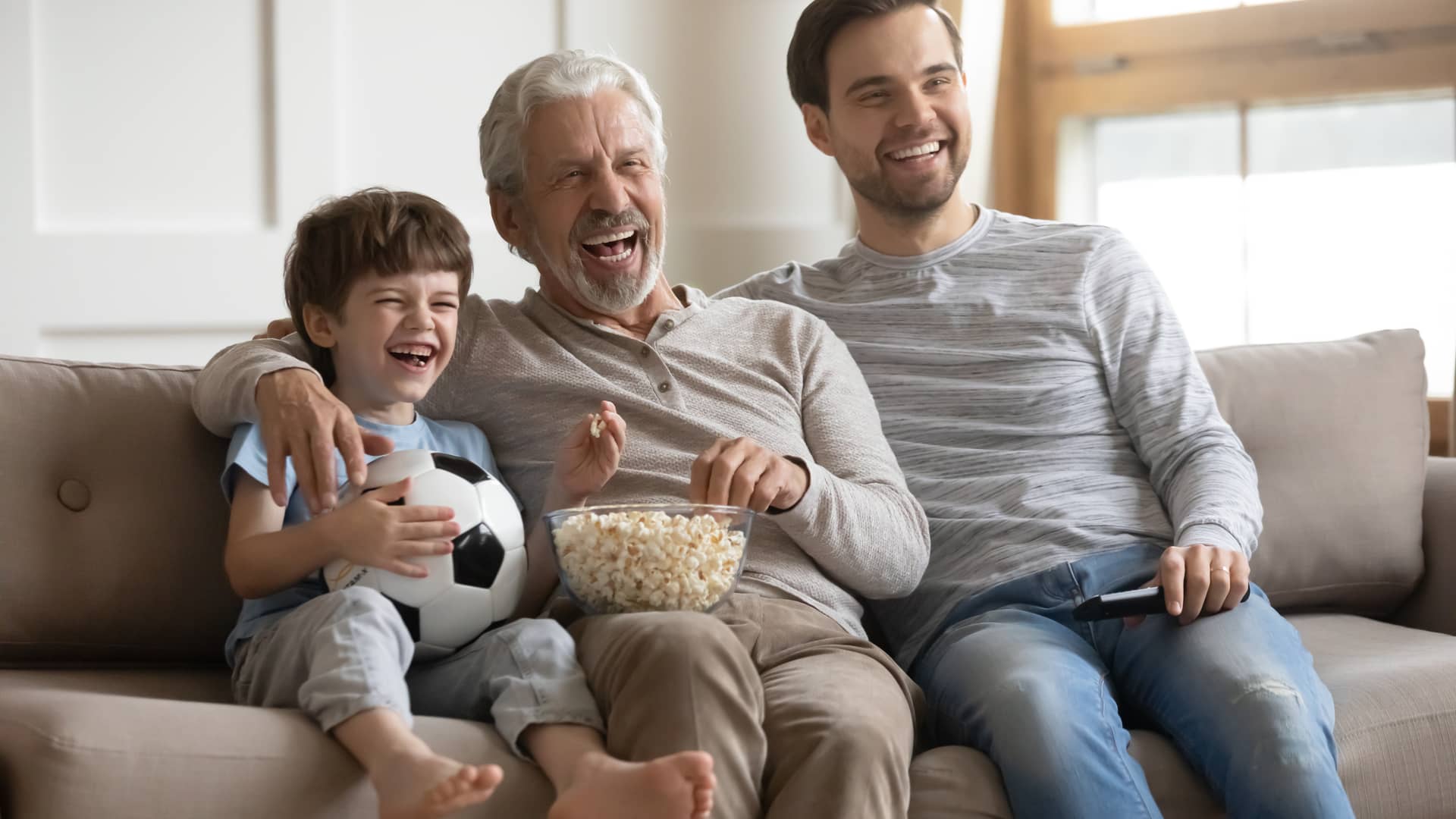 Abuelo, padre e hijo viendo la tv plus de la empresa telefonica sky