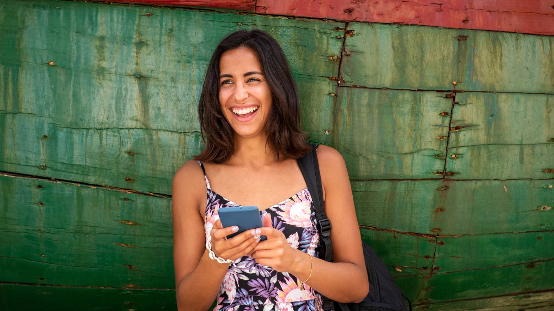 Mujer sonriente con el celular tras concoer los paquetes de internet de telmex