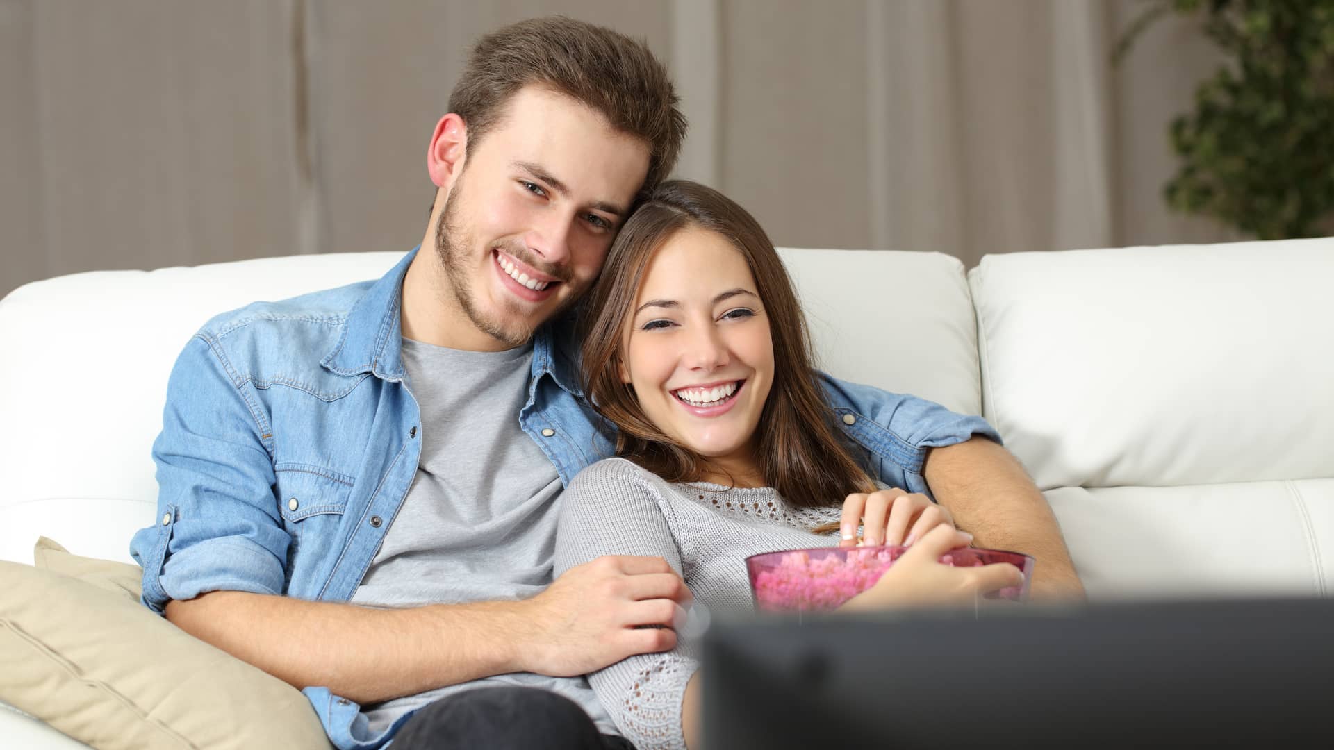 pareja joven disfrutando de los canales de tv de la empresa wizziplus